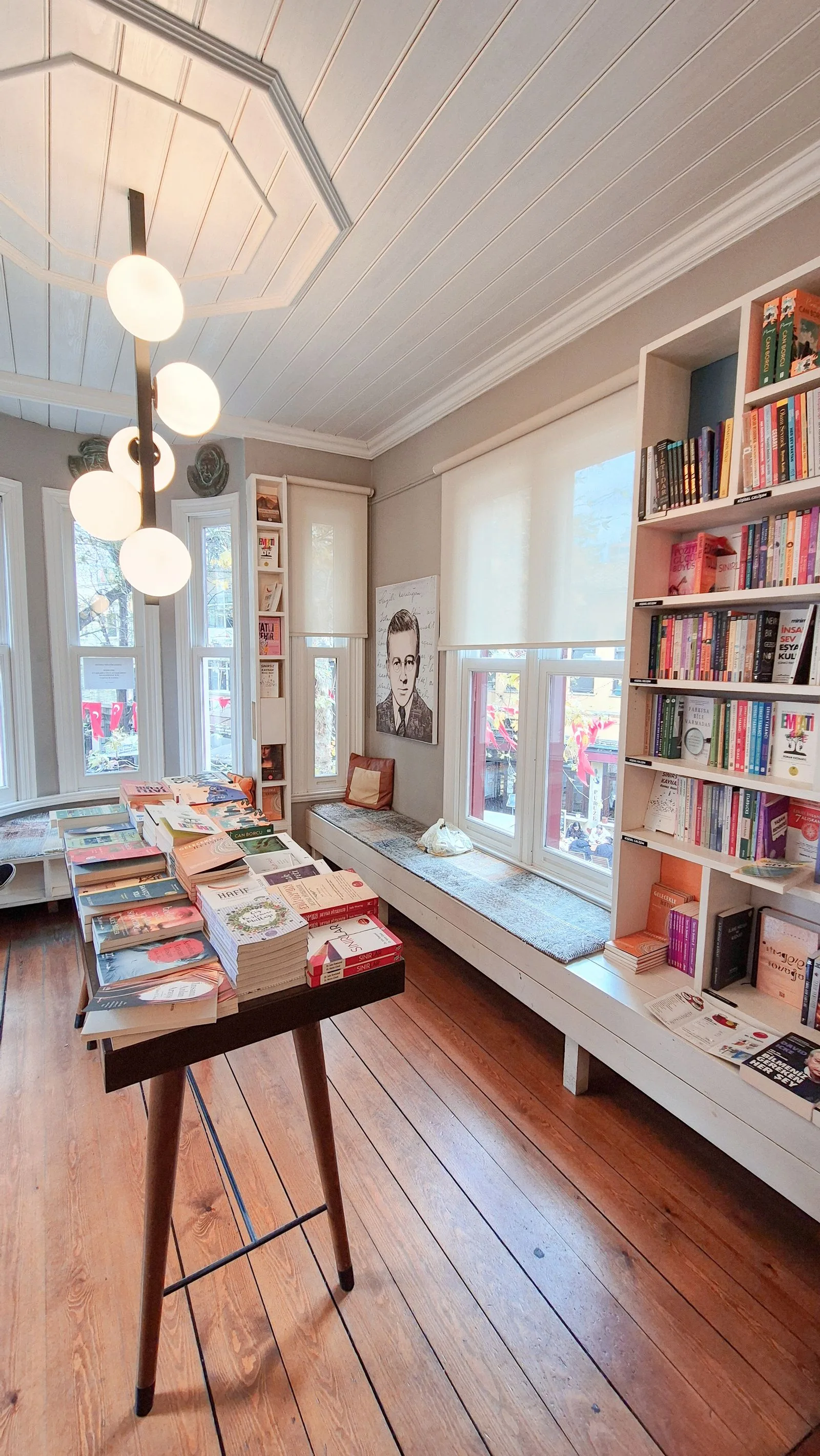 The warm interior of a cosy independent bookshop, shelves stacked with books